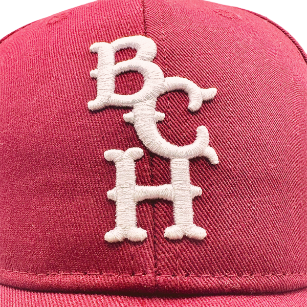 Gorra hombres color rojo con letras BCH bordadas en blanco, estilo beisbolero de la marca Bench.