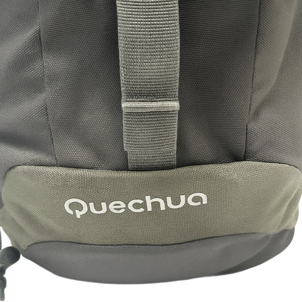 Mochila montaña Quechua Arpenaz gris, detalle de tela resistente y asa superior.