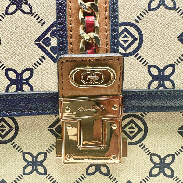 Close-up of Aldo Donelly women's purse with gold clasp, chain detail, and blue geometric pattern.
