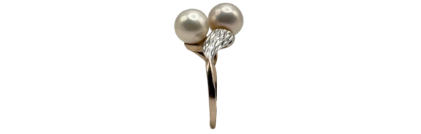 Elegant golden ring with two pearls and delicate leaf detail, perfect for a refined look. Golden golden ring design.