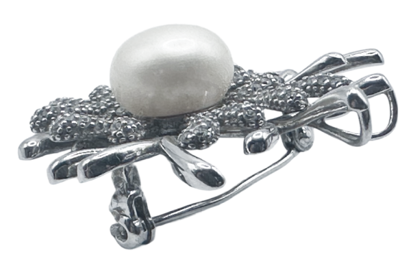 Broche de plata con detalle de coral y perla, elegante accesorio de moda para realzar cualquier conjunto.