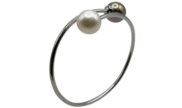 Elegant pearl bracelet with black and white pearls on a sleek silver bangle, perfect for any occasion.