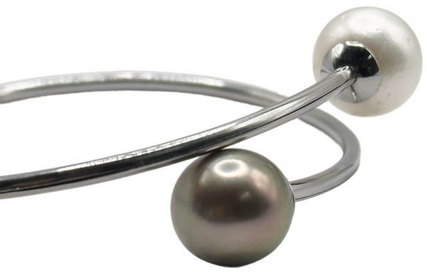 Pulsera elegante con perlas blancas y negras, diseño moderno en plata ideal para cualquier ocasión.